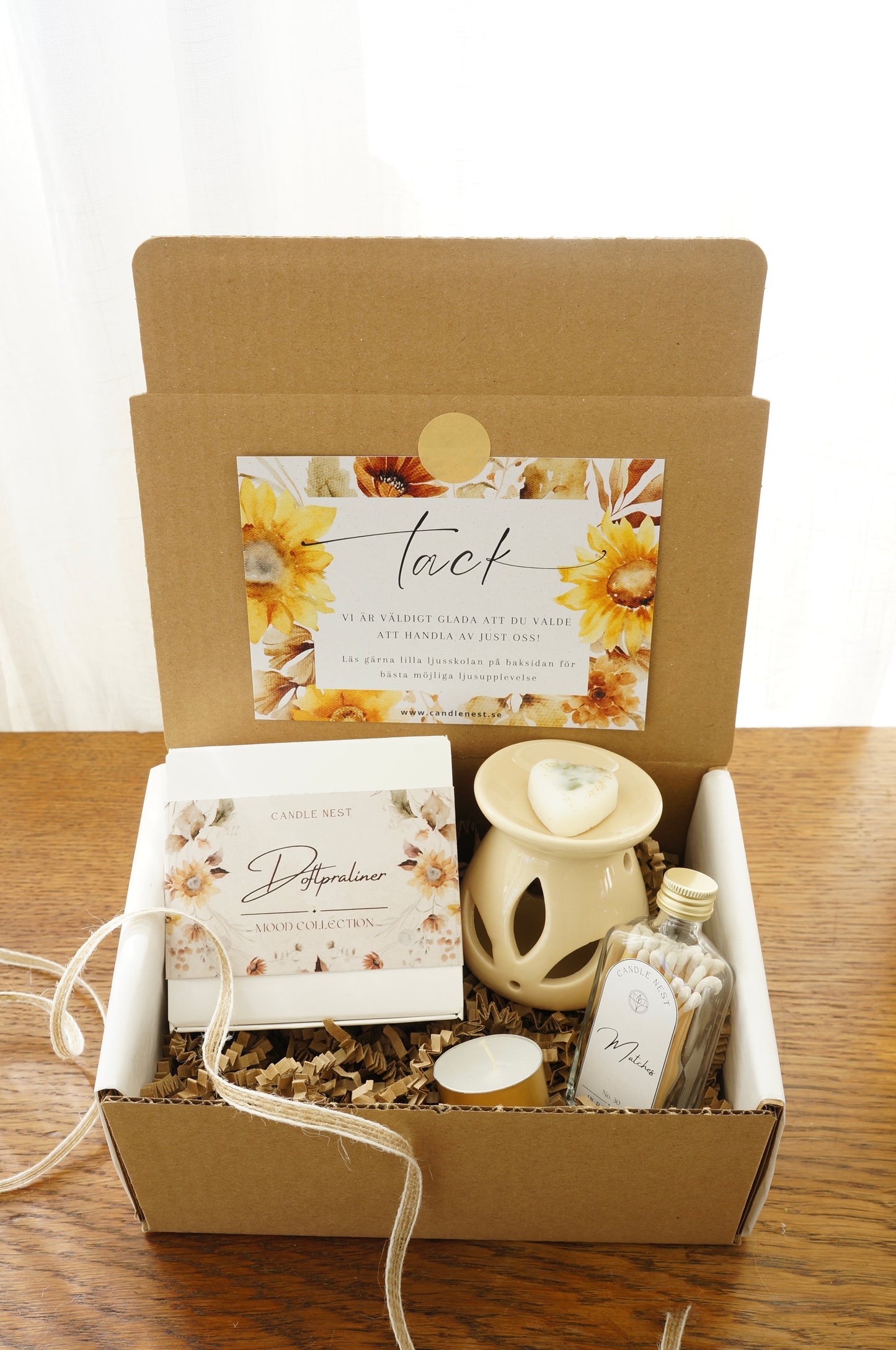 Presentbox med Doftpraliner, aromalampa och flaska med tändstickor.Bild snett ovanifrån.