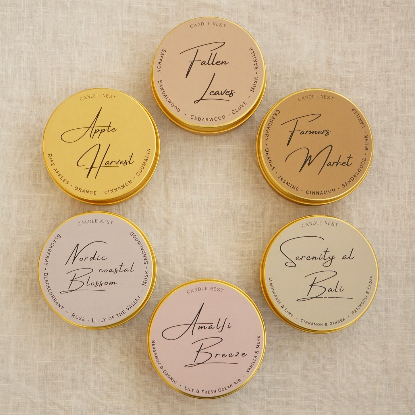 candle nest doftljus. bild från ovan på alla 6 dofljus i guldiga aluminiumburkar. Ljusen har olika färger på etiketterna med ljusens namn på.