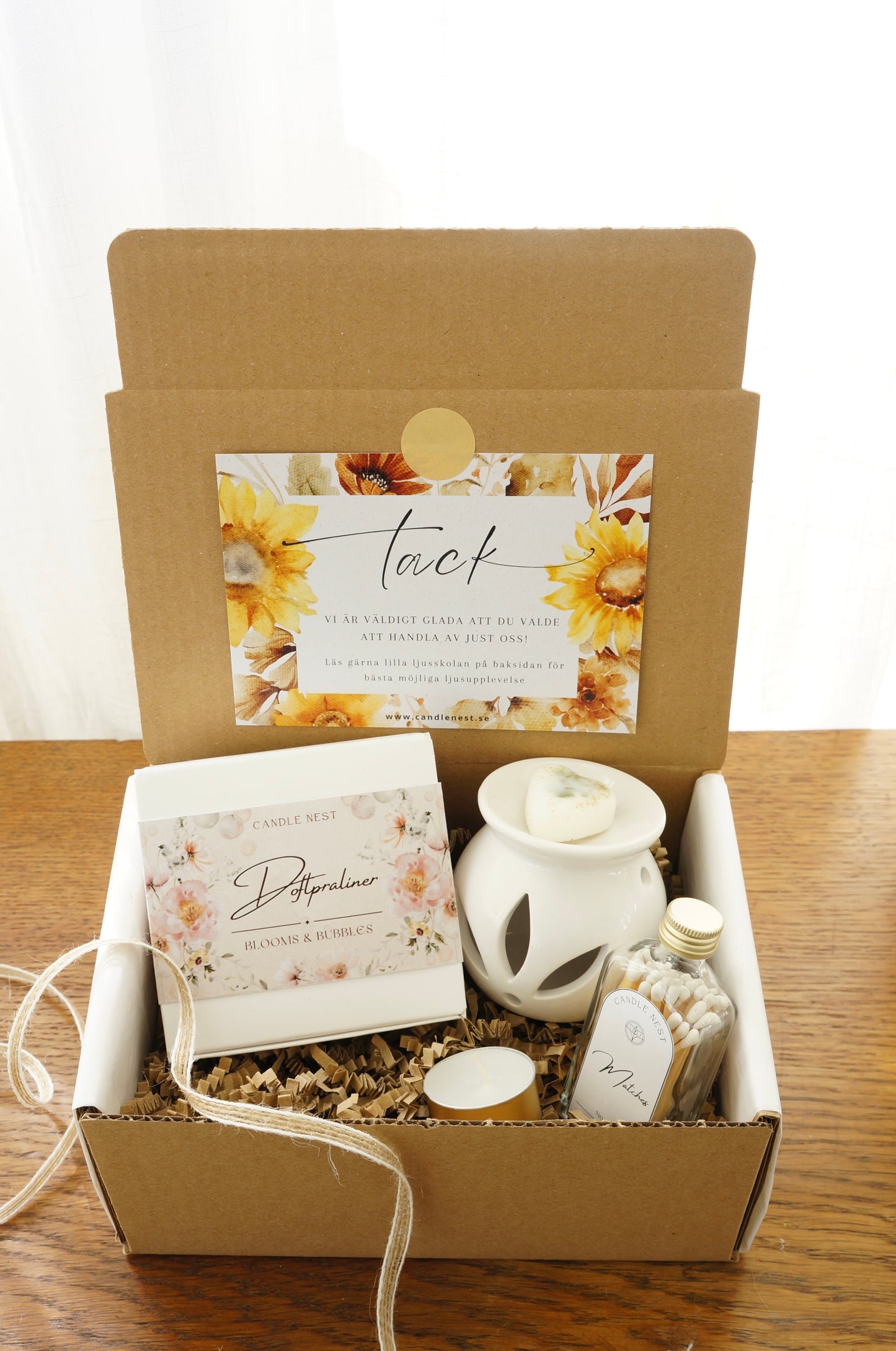 Presentbox med Doftpraliner, aromalampa och flaska med tändstickor.Bild snett ovanifrån.