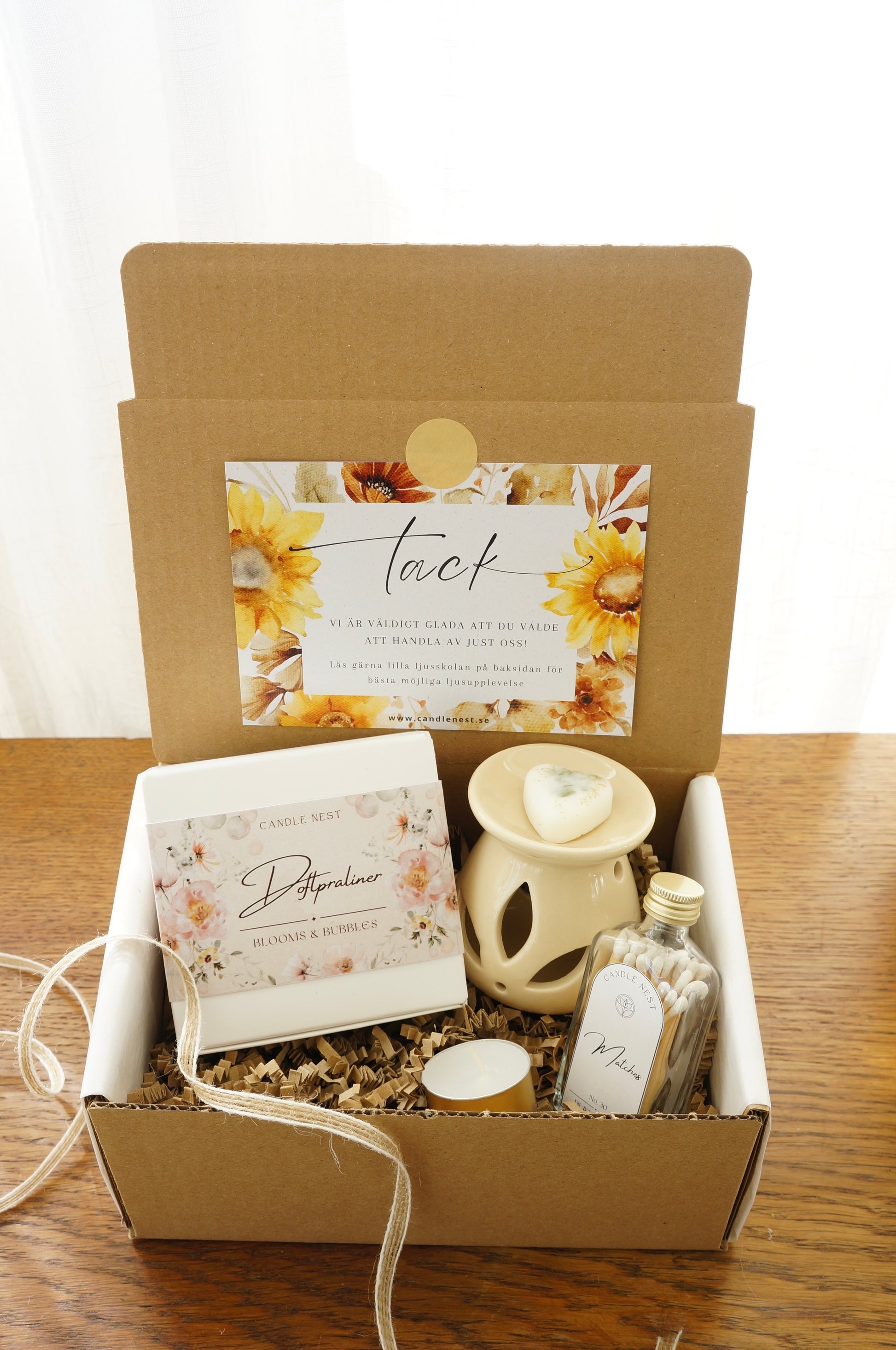 Presentbox med Doftpraliner, aromalampa och flaska med tändstickor.Bild snett ovanifrån.