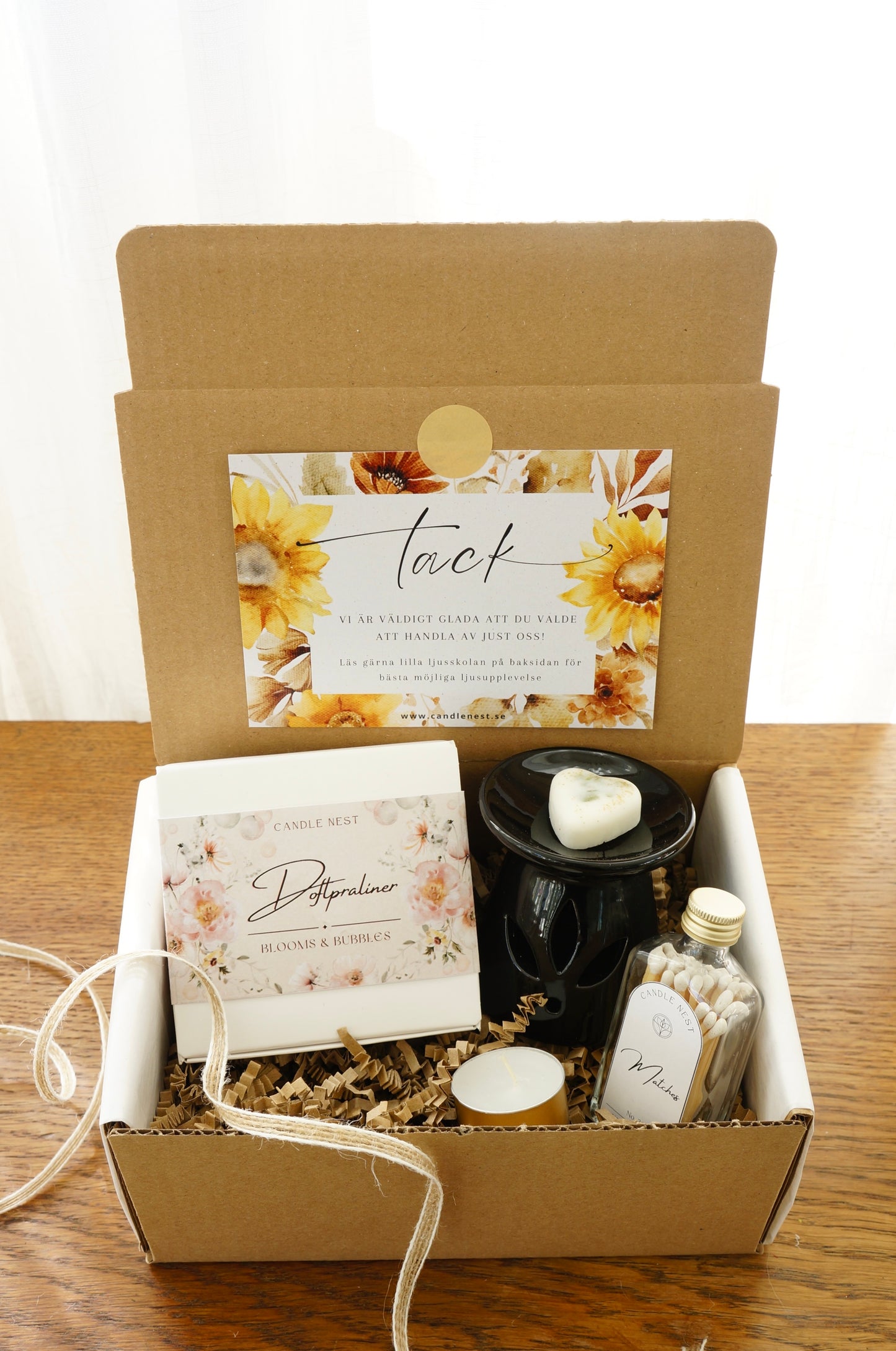 Presentbox med Doftpraliner, aromalampa och flaska med tändstickor.Bild snett ovanifrån.