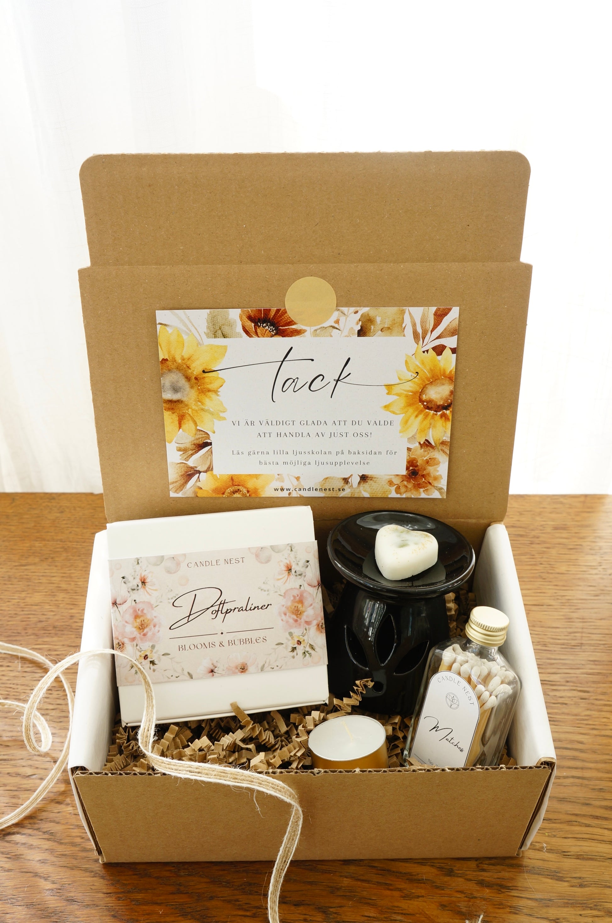 Presentbox med Doftpraliner, aromalampa och flaska med tändstickor.Bild snett ovanifrån.