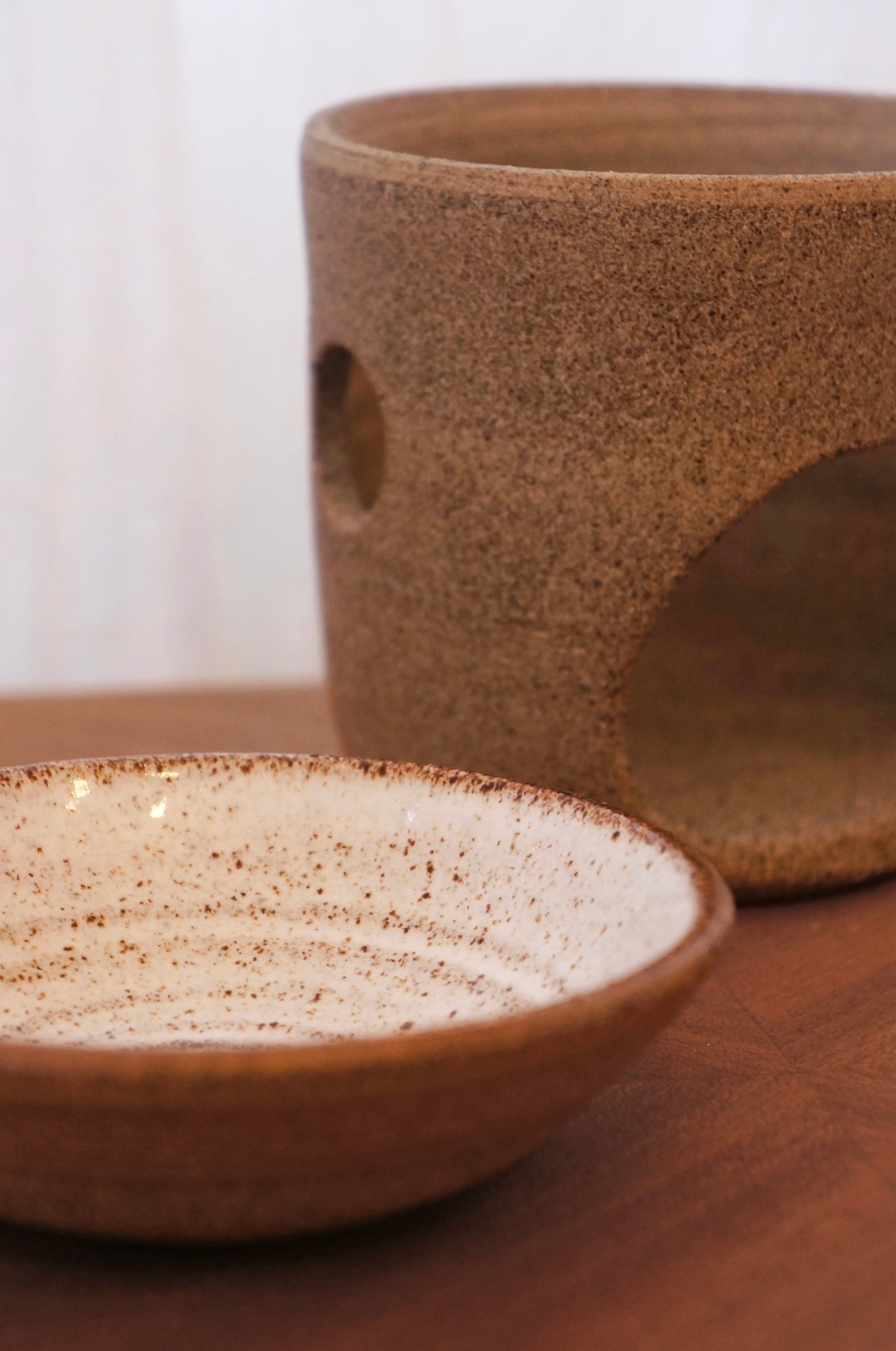 Detaljbild på aromalampans vita glaserade yta med synliga handgjorda ojämnheter och grå matt botten