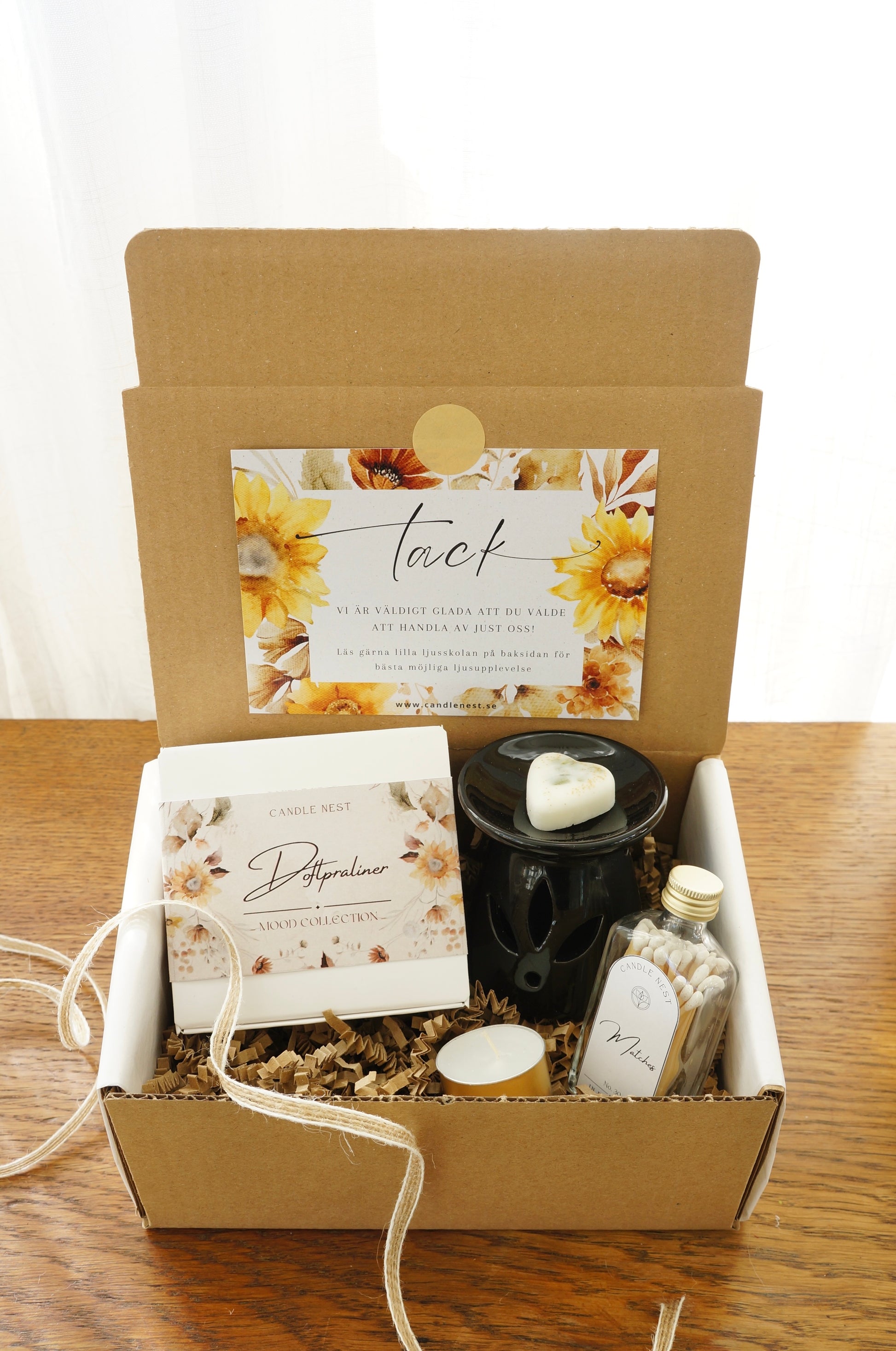 Presentbox med Doftpraliner, aromalampa och flaska med tändstickor.Bild snett ovanifrån.