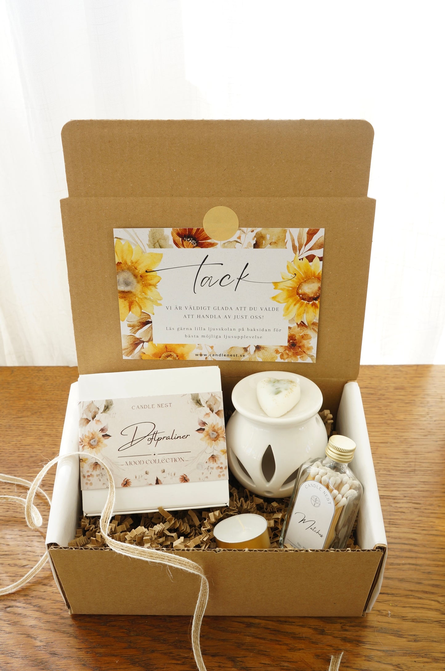 Presentbox med Doftpraliner, aromalampa och flaska med tändstickor.Bild snett ovanifrån.